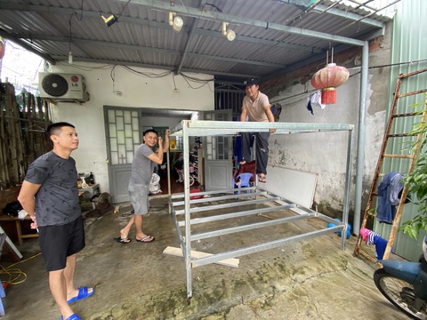 Rốn lũ Đà Nẵng hối hả dời nhà, sơ tán dân ứng phó đợt mưa lớn - Ảnh 9. Người dân trong vùng ngập hàn khung sắt để gác đồ đạc, kết hợp người ngồi lên khi nước dâng cao - Ảnh: B.D.