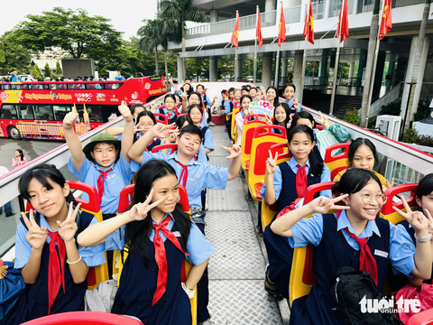 Học sinh TP.HCM hào hứng học giáo dục địa phương trên xe buýt 2 tầng - Ảnh 1. Xe buýt hai tầng đến trường đón học sinh tham gia hành trình Sài Gòn rong ca - Ảnh: M.G.