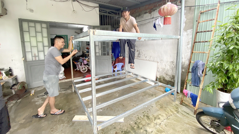 Dân Đà Nẵng biến nhà thành lô cốt chống ngập - Ảnh 1. Nhà hẻm 127 Mẹ Suốt hàn khung sắt kê đồ đạc và người ngồi lên trên đó khi lụt cao - Ảnh: B.D.