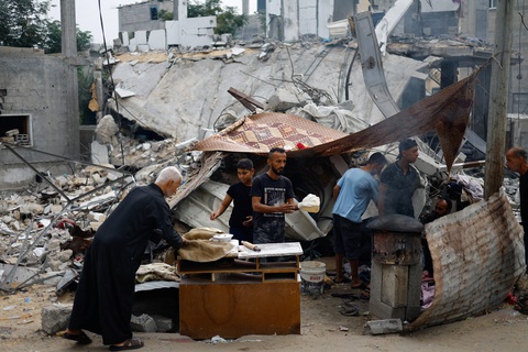Người Palestine chuẩn bị thức ăn bên cạnh đống đổ nát của các tòa nhà tại Khan Younis, miền Nam Gaza, ngày 13-11 - Ảnh: REUTERS Người Palestine chuẩn bị thức ăn bên cạnh đống đổ nát của các tòa nhà tại Khan Younis, miền nam Gaza, ngày 13-11 - Ảnh: REUTERS