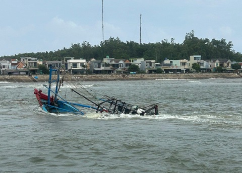 Tàu cá bị sóng đánh chìm, 5 ngư dân thoát chết - Ảnh 1. Tàu cá bị chìm, được lai dắt vào bờ - Ảnh: B.P.
