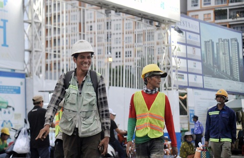Gỡ khó cho bất động sản: Hàng dài kiến nghị và... kiến nghị - Ảnh 2. Công nhân tan ca tại công trường xây dựng dự án bất động sản trên đường Nguyễn Hữu Thọ, huyện Nhà Bè, TP.HCM - Ảnh: TỰ TRUNG