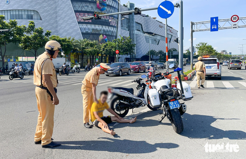 Thanh niên nghi ngáo đá, lấy xe máy chắn ngang làn ô tô đường Phạm Văn Đồng - Ảnh 3. Các chiến sĩ Đội cảnh sát giao thông Hàng Xanh khuyên ngăn nam thanh niên - Ảnh: LÊ PHAN