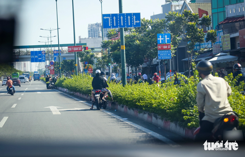 Gặp cảnh sát khi vào đường cấm, người lái xe máy quay ngược chiều 'tẩu thoát' - Ảnh 1. Thấy chốt của Đội cảnh sát giao thông Hàng Xanh, hàng loạt xe máy đang chạy vào đường cấm (làn ô tô đường Phạm Văn Đồng) quay đầu bỏ chạy - Ảnh: CHÂU TUẤN