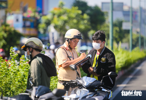 Gặp cảnh sát khi vào đường cấm, người lái xe máy quay ngược chiều 'tẩu thoát' - Ảnh 3. Anh N.V.T. (một người bị thổi phạt) cho biết anh vi phạm lỗi chạy vào làn ô tô trong giờ cấm vì quên xem đồng hồ. "Tôi chạy lố có vài phút nhưng vẫn bị phạt. Đang có việc chạy vội nên không để ý đã vào giờ cấm", anh T. nói - Ảnh: LÊ PHAN