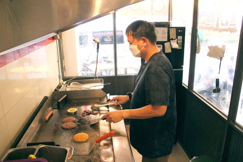 Quán burger Mỹ làm khách vui của Charlie Tạ - Ảnh 1. Charlie Tạ làm burger cho khách - Ảnh: NGỌC ĐÔNG