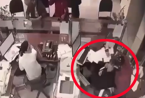 Người đàn ông bịt mặt nghi dùng dao cướp ngân hàng ở Cửa Lò - Ảnh 1. Người đàn ông dùng vật nhọn nghi là dao khống chế nữ nhân viên ngân hàng - Ảnh: Bạn đọc cung cấp
