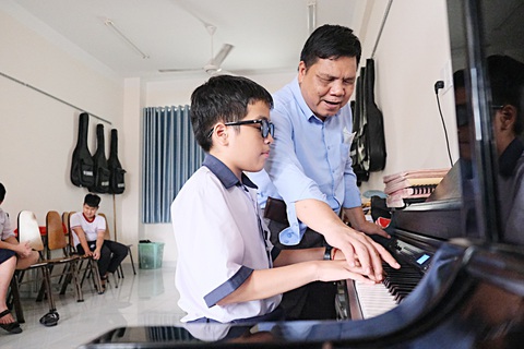Người thầy, người anh, nhà tâm lý - Ảnh 3. Thầy Thanh và các em trong buổi học nhạc - Ảnh: NG. PHƯỢNG