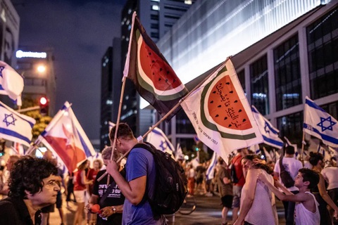 Người biểu tình mang lá cờ dưa hấu thay cho lá cờ Palestine , trong cuộc tuần hành ở Tel Aviv (Israel) - Ảnh: BUSINESS INSIDER Người biểu tình mang lá cờ dưa hấu thay cho lá cờ Palestine trong một cuộc tuần hành ở Tel Aviv (Israel) - Ảnh: BUSINESS INSIDER