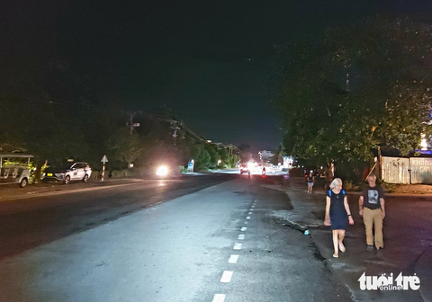 Đường Trần Hưng Đạo ở Phú Quốc chưa lắp đèn đường: Lãnh đạo địa phương nói gì? - Ảnh 1. Đoạn đường Trần Hưng Đạo (đoạn từ cổng chào đến ngã 5 chợ đêm Phú Quốc) chưa lắp đèn đường chiếu sáng nên khách du lịch lội bộ thầm trong đêm - Ảnh: CHÍ CÔNG