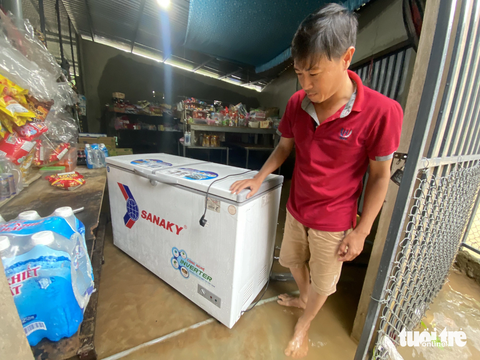 Nước lũ từ thượng nguồn Bạch Mã đổ về rạng sáng, dân không kịp trở tay - Ảnh 3. Tủ lạnh và một số hàng hóa ở quán tạp hóa của ông Thiện bị ngập trong nước lũ từ rạng sáng nay - Ảnh: LÊ TRUNG