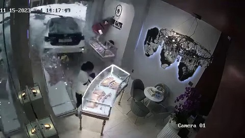 Nữ tài xế lùi xe tông cửa hàng trang sức, một bảo vệ nguy kịch - Ảnh 1. Khoảnh khắc chiếc xe ô tô do nữ tài xế điều khiển lùi tông trúng cửa hàng bán đồ trang sức và làm một bảo vệ tại đây bị thương nặng - Ảnh: Cắt từ video