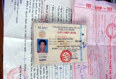 Trừ điểm bằng lái tài xế vi phạm? - Ảnh 6. Trước đây để siết chặt quản lý tài xế vi phạm giao thông, nhà chức trách đưa ra giải pháp bấm lỗ bằng lái... Trong ảnh: bằng lái bị bấm lỗ vì sai phạm (ảnh chụp năm 2005) - Ảnh: T.L.