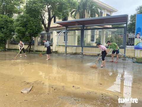 Người dân Huế tất bật dọn dẹp nhà cửa, trụ sở, đường sá sau khi nước lũ rút- Ảnh 1. Nhân viên một trụ sở nhà nước dọn vệ sinh sau khi lũ rút - Ảnh: LÊ TRUNG