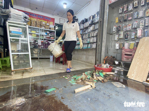 Người dân Huế tất bật dọn dẹp nhà cửa, trụ sở, đường sá sau khi nước lũ rút- Ảnh 4. Nhiều thiết bị điện thoại tại cửa hàng của ông Đô bị hư hỏng do ngập lũ - Ảnh: LÊ TRUNG