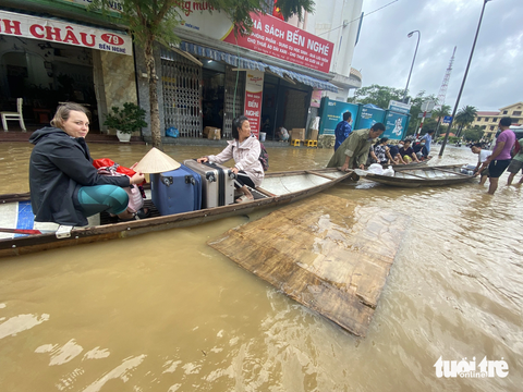 Người dân Huế tất bật dọn dẹp nhà cửa, trụ sở, đường sá sau khi nước lũ rút- Ảnh 12. Dùng ghe thuyền đưa khách du lịch ra khỏi vùng ngập lũ - Ảnh: LÊ TRUNG