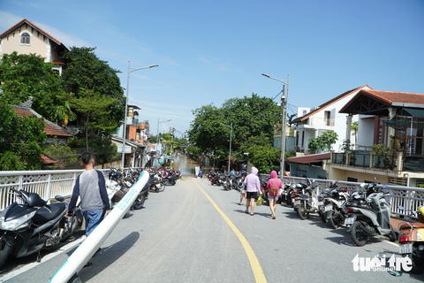 Trời nắng, nhiều tuyến phố ở Huế vẫn còn chìm trong nước lũ - Ảnh 10. Rất nhiều xe máy mà người dân đưa đi tránh lũ vẫn còn để trên cầu Đông Ba - Ảnh: LÊ TRUNG