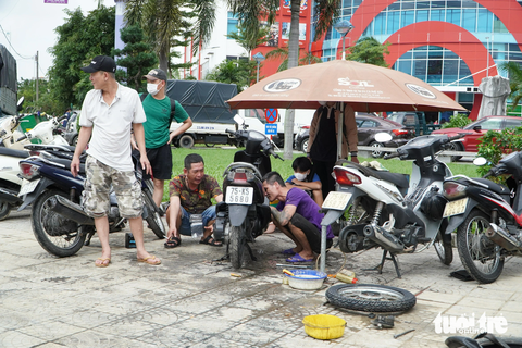 Trời nắng, nhiều tuyến phố ở Huế vẫn còn chìm trong nước lũ - Ảnh 11. Sau lũ, có hàng chục điểm sửa xe máy trên vỉa hè Huế - Ảnh: LÊ TRUNG
