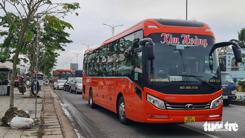 Tai nạn liên hoàn buổi sáng, cầu Rạch Miễu kẹt xe kéo dài sang chiều - Ảnh 5. Hai chiếc xe khách Kim Hoàng chạy lấn hết làn đường xe máy trên quốc lộ 60, tỉnh Bến Tre khiến xe máy phải chạy lên lề - Ảnh: MẬU TRƯỜNG