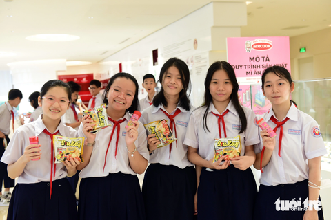 ‘Đi tham quan nhà máy em biết thêm nhiều kiến thức mới’ - Ảnh 1. Các em học sinh vui vẻ ghi lại hình ảnh của mình bên các sản phẩm khác nhau của Acecook - Ảnh: DUYÊN PHAN