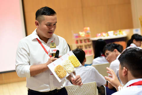 ‘Đi tham quan nhà máy em biết thêm nhiều kiến thức mới’ - Ảnh 3. Anh Ngọc Hiền - nhân viên của Tập đoàn Acecook - hướng dẫn cho học sinh biết về mì chiên và mì không chiên - Ảnh: DUYÊN PHAN