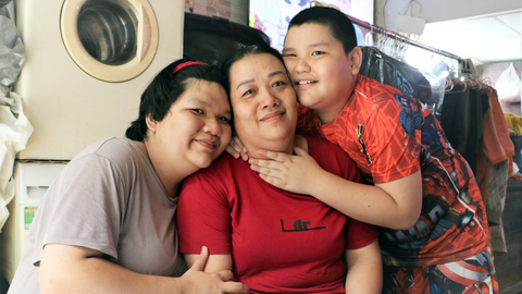 Học, kiếm tiền và đưa mẹ về quê - Ảnh 1. Trương Ái Nhi (trái) cùng mẹ và cậu em trai út trong tiệm giặt ủi là công việc kiếm sống của cả nhà - Ảnh: BÌNH MINH