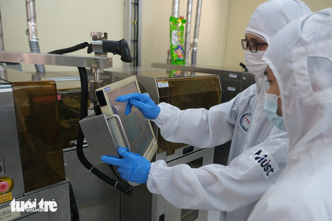 Đào tạo nhân lực ngành chip bán dẫn ra sao? - Ảnh 1. Hai nghiên cứu sinh Việt Nam đang vận hành hệ thống thiết bị sản xuất vi mạch bán dẫn tại Đại học khoa học - công nghệ Minghsin (Đài Loan) - Ảnh: VI HOÀNG