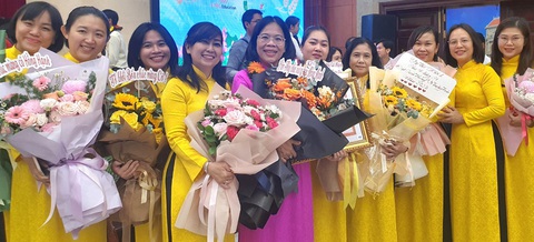 TP.HCM vinh danh 50 nhà giáo tiêu biểu- Ảnh 1. Đồng nghiệp chúc mừng cô Trần Bé Hồng Hạnh - hiệu trưởng Trường tiểu học Nguyễn Thái Học, quận 1 (áo tím) - tại buổi lễ vinh danh 50 nhà giáo tiêu biểu của TP.HCM