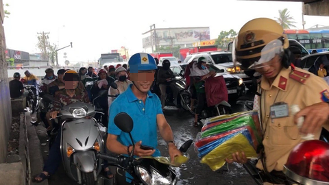 Cảnh gây tranh cãi trên đường mỗi khi trời mưa: Trú mưa dưới gầm cầu - Ảnh 2. Trú mưa dưới gầm cầu cũng là hiện tượng diễn ra phổ biến ở Việt Nam. Trong ảnh: Cảnh sát giao thông phát áo mưa và giải tán xe máy trú mưa dưới gầm cầu gây cản trở giao thông - Ảnh: M.V.