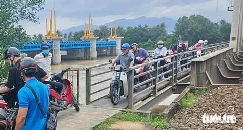 Cầu gỗ Nha Trang bị lũ cuốn trôi, nhiều học sinh phải nghỉ học ở nhà - Ảnh 2. Cầu gỗ Phú Kiểng bị cuốn trôi, người dân phải chen chúc qua cầu đường sắt - Ảnh: MINH CHIẾN
