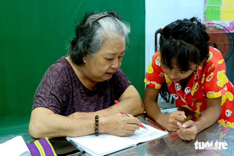 "Bà Ngoại Thủy " chám bài cuối buổi học cho các cháu - Ảnh: DIỆU LINH "Bà ngoại Thủy" chấm bài cuối buổi học cho các cháu - Ảnh: DIỆU LINH