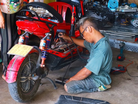 Ông Nguyễn Văn Sinh đang sửa chữa bình ăcquy cho một xe đạp điện của học sinh - Ảnh: HOÀNG DƯƠNG Ông Nguyễn Văn Sinh sửa chữa bình ắc quy cho một xe đạp điện của học sinh - Ảnh: HOÀNG DƯƠNG