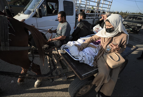 Bệnh viện Al Shifa tại Dải Gaza gấp rút sơ tán - Ảnh 2. Một người bệnh được người thân tháp tùng di chuyển xuống phía nam - Ảnh: WASHINGTON POST