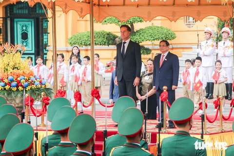 Thủ tướng Phạm Minh Chính đón Thủ tướng Hà Lan Mark Rutte - Ảnh 3. Hai nhà lãnh đạo cùng bước lên bục nghi lễ. Quốc thiều hai nước lần lượt được cử lên - Ảnh: DUY LINH