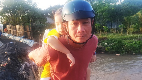 Mất hơn 1 giờ để di chuyển khoảng 1km qua đoạn đường sạt lở - Ảnh 2. Ông Hồ Văn Pháp hằng ngày phải hai lần cõng bé học mẫu giáo đến trường do đường sạt lở không chạy xe được