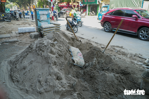 'Đến hẹn lại lên', cuối năm, loạt vỉa hè ở Hà Nội lại bị xới tung để... lát lại - Ảnh 5. Những đống xi măng trộn cát lớn trên vỉa hè cản trở việc đi lại của người dân - Ảnh: PHẠM TUẤN