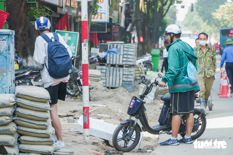 'Đến hẹn lại lên', cuối năm, loạt vỉa hè ở Hà Nội lại bị xới tung để... lát lại - Ảnh 6. Em học sinh gặp khó khi dắt xe vào cửa hàng văn phòng phẩm để mua đồ dùng học tập - Ảnh: PHẠM TUẤN