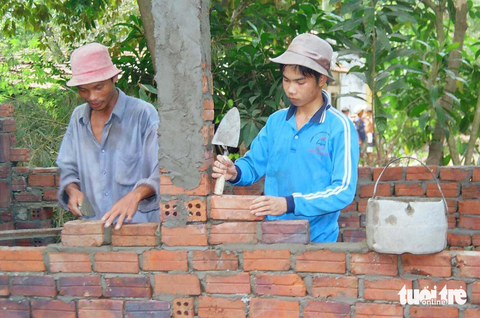 Hành trình 20 năm viết nên những câu chuyện đẹp của cuộc đời - Ảnh 5. Nguyễn Lương Nhã, cậu học trò không cha, mẹ chỉ còn một cánh tay, đậu vào Trường ĐH Kinh tế TP.HCM năm 2004 khiến ai nấy đều thán phục. Sinh ra ở Tam Phú là xã nghèo nhất ở thị xã Tam Kỳ (Quảng Nam), nhà Nhã còn là nhà nghèo nhất xóm, không sống đủ với mấy vạt ruộng cằn cũng như làm thuê làm mướn cho bà con, mẹ Nhã đã quẩy gánh lên thị xã mua hàng về bán dạo cho bà con trong làng ngoài xã. Còn Nhã ngay sau khi biết tin mình đậu, cậu đã bàn với mẹ xin đi làm phụ hồ để kiếm tiền đi học - Ảnh: HUỲNH VĂN MỸ