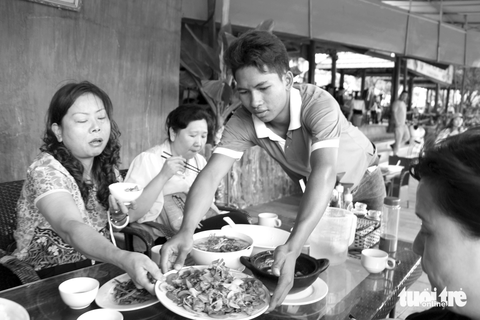 Hành trình 20 năm viết nên những câu chuyện đẹp của cuộc đời - Ảnh 9. Dưới mái tôn nóng hầm hập như lò nung trong quán ăn ven quốc lộ 27C đi qua xã Sơn Thái (huyện Khánh Vĩnh, Khánh Hòa), Cao Thành Tâm, tân sinh viên ngành ngôn ngữ Anh Trường ĐH Nha Trang (năm 2018), vẫn tất tả chạy bàn giữa dòng khách nườm nượp vào quán. Phía sau dáng hình gầy gò, sức vóc nhỏ bé, cậu học trò 18 tuổi người Raglai Cao Thành Tâm đang gánh trên vai bộn bề những lo toan: kiếm tiền nuôi mẹ đang chạy thận, lo cho đứa em ăn uống và số tiền học trang trải những ngày tháng vào ĐH sắp tới - Ảnh: THÁI THỊNH