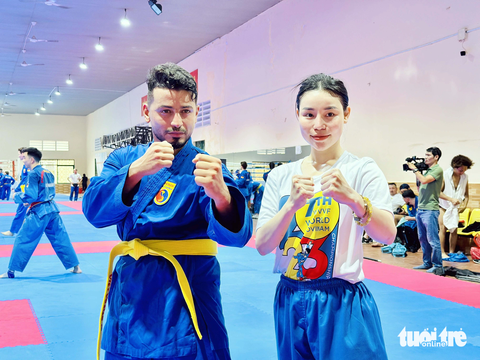 Vận động viên quốc tế làm nóng trước thềm giải Vovinam thế giới tại Việt Nam - Ảnh 9. VĐV Majdi Al Shtewi (Libya) chụp ảnh cùng tình nguyện viên giúp mình tập bài quyền mới