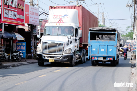 Kinh hãi xe container 'đẩy' xe máy chạy ngược chiều trên đường Vĩnh Lộc- Ảnh 3. Xe container và xe tải lưu thông cùng thời điểm, chạy trên hai làn đường đã chiếm gần hết mặt đường Vĩnh Lộc. Khi các xe lớn này chạy trước, xe máy muốn qua mặt phải vượt trái qua làn đường ngược chiều hoặc chạy lên vỉa hè