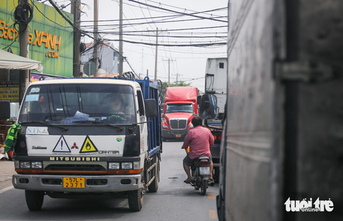 Cận cảnh đường 'tử thần' Nguyễn Duy Trinh: 4 năm, 21 người mất mạng- Ảnh 1. Đường Nguyễn Duy Trinh là đường độc đạo dẫn vào cảng Phú Hữu nên xe tải cỡ lớn và xe container chiếm số nhiều. Xe máy hầu như phải luồn lách để đi lại - Ảnh: LÊ PHAN
