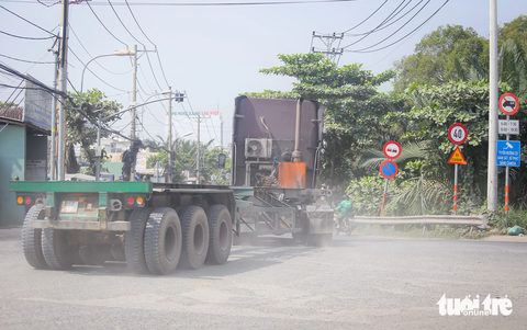 Cận cảnh đường 'tử thần' Nguyễn Duy Trinh: 4 năm, 21 người mất mạng- Ảnh 5. Đặc biệt, tại giao lộ Nguyễn Duy Trinh - Nguyễn Thị Tư (lối vào cảng Phú Hữu), bụi bặm mù trời khiến việc đi lại của người dân càng trở nên khó khăn - Ảnh: CHÂU TUẤN