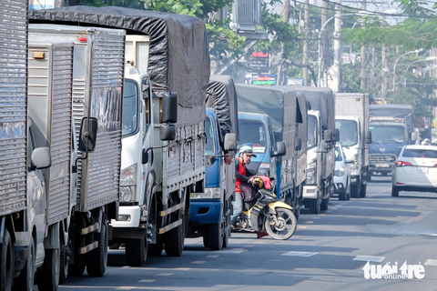 Kinh hãi xe container 'đẩy' xe máy chạy ngược chiều trên đường Vĩnh Lộc- Ảnh 4. Kẹt xe trên đường Vĩnh Lộc hướng từ huyện Hóc Môn đi Bình Chánh, trưa 21-11. Một người điều khiển xe máy bất chấp nguy hiểm, len lỏi giữa hàng dài xe tải để chạy ngược chiều nhằm thoát khỏi dòng xe đang "đứng im"