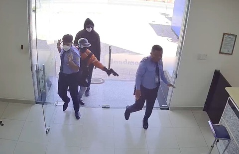 Báo động tình trạng lên mạng rủ nhau làm liều- Ảnh 1. Mỹ và Lợi trực tiếp dùng súng vào khống chế bảo vệ rồi cướp 3,8 tỉ đồng ở Hóc Môn, ngày 24-10 - Ảnh: Cắt từ camera