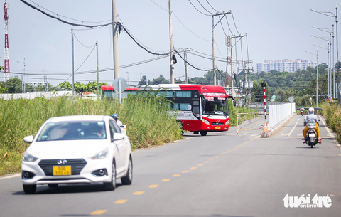 Khu dân cư bị bít lối, 300 người phải đi nhờ đường bến xe Miền Đông mới- Ảnh 7. Phía bến xe Miền Đông mới đã dựng hàng rào giữa con đường để ngăn cách lối đi cho cư dân với lối đi của xe khách ra vào bến xe để giảm va chạm giao thông - Ảnh: CHÂU TUẤN