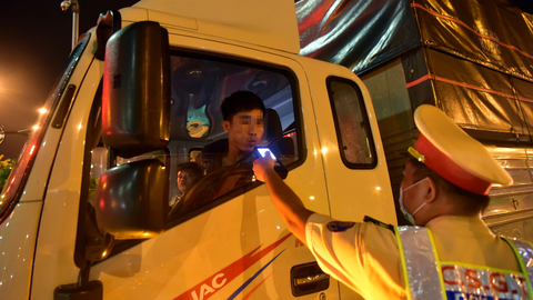Cấm tuyệt đối nồng độ cồn với tài xế: Đừng để xảy ra bất cập!- Ảnh 1. Lái xe tải thổi vào máy đo nồng độ cồn của CSGT khi lưu thông từ cao tốc ra đường Mai Chí Thọ, TP Thủ Đức, TP.HCM - Ảnh: T.T.D.
