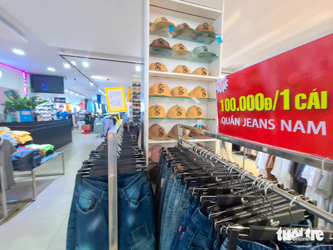Dịp Black Friday đông đúc nhờ khách đi xem, ăn uống, giải trí- Ảnh 2. Cửa hàng thuộc thương hiệu thời trang Sea Collection nằm trên đường Nguyễn Trãi (quận 5) tung chương trình đồng giá quần jeans 100.000 đồng/chiếc Black Friday. Quản lý cửa hàng cho hay đây đều là các sản phẩm mới, không phải hàng tồn kho - Ảnh: NHẬT XUÂN