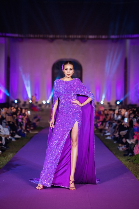 Thanh Hằng khoe sắc vóc với thiết kế gam tím lấp lánh thuộc bộ sưu tập 'Duyên' của nhà thiết kế Adrian Anh Tuấn. Trong phần trình diễn vào chiều 24-11, 'chị đại' làng mốt gây ấn tượng khi diện bộ đầm ống ngang ngực gam tím lấp lánh, đi kèm là áo choàng kép tiệp màu dài quét đất. Nhiều người nhận xét Thanh Hằng ngày càng đằm thắm, nữ tính.
