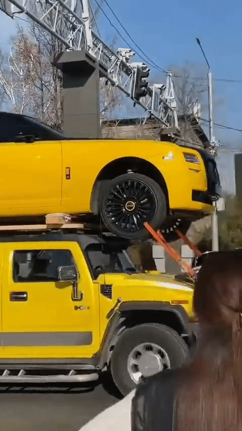 Hummer H2 cõng Rolls-Royce Ghost dạo phố- Ảnh 1. Hình ảnh chiếc Hummer H2 cõng Rolls-Royce Ghost với tông màu đôi vàng tươi sáng khiến người đi đường trầm trồ - Ảnh cắt từ video, nguồn RB Life